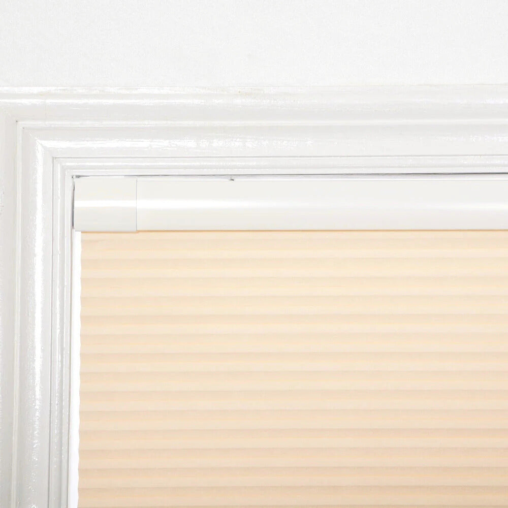 Beige no-drill honeycomb shades installed on a white window frame with tool-free, no-nail system design