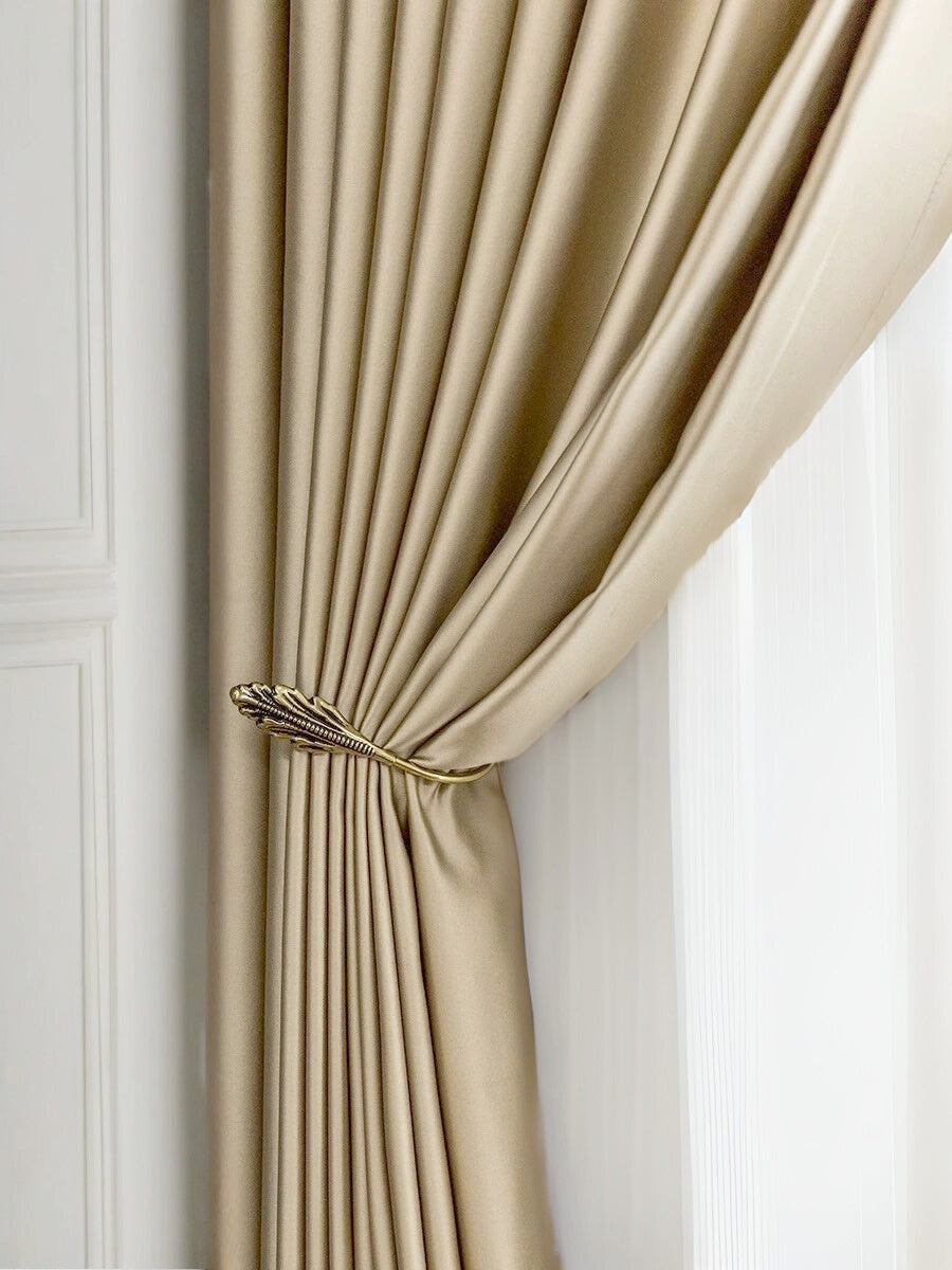 Elegant beige silk curtains with smooth draping tied back, showcasing luxury and softness