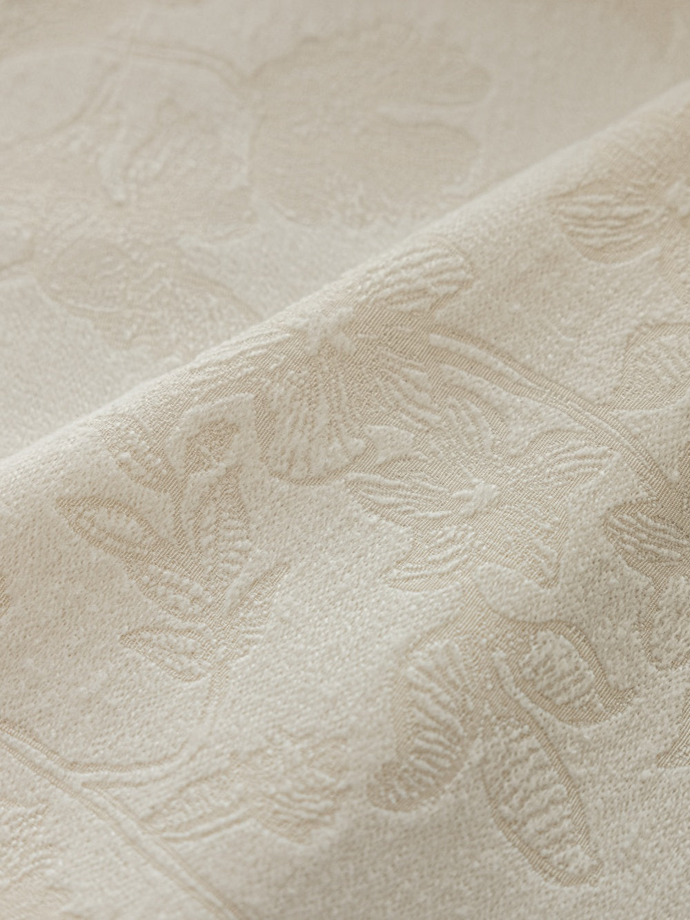 Embossed white blackout curtain fabric with French-inspired design.
