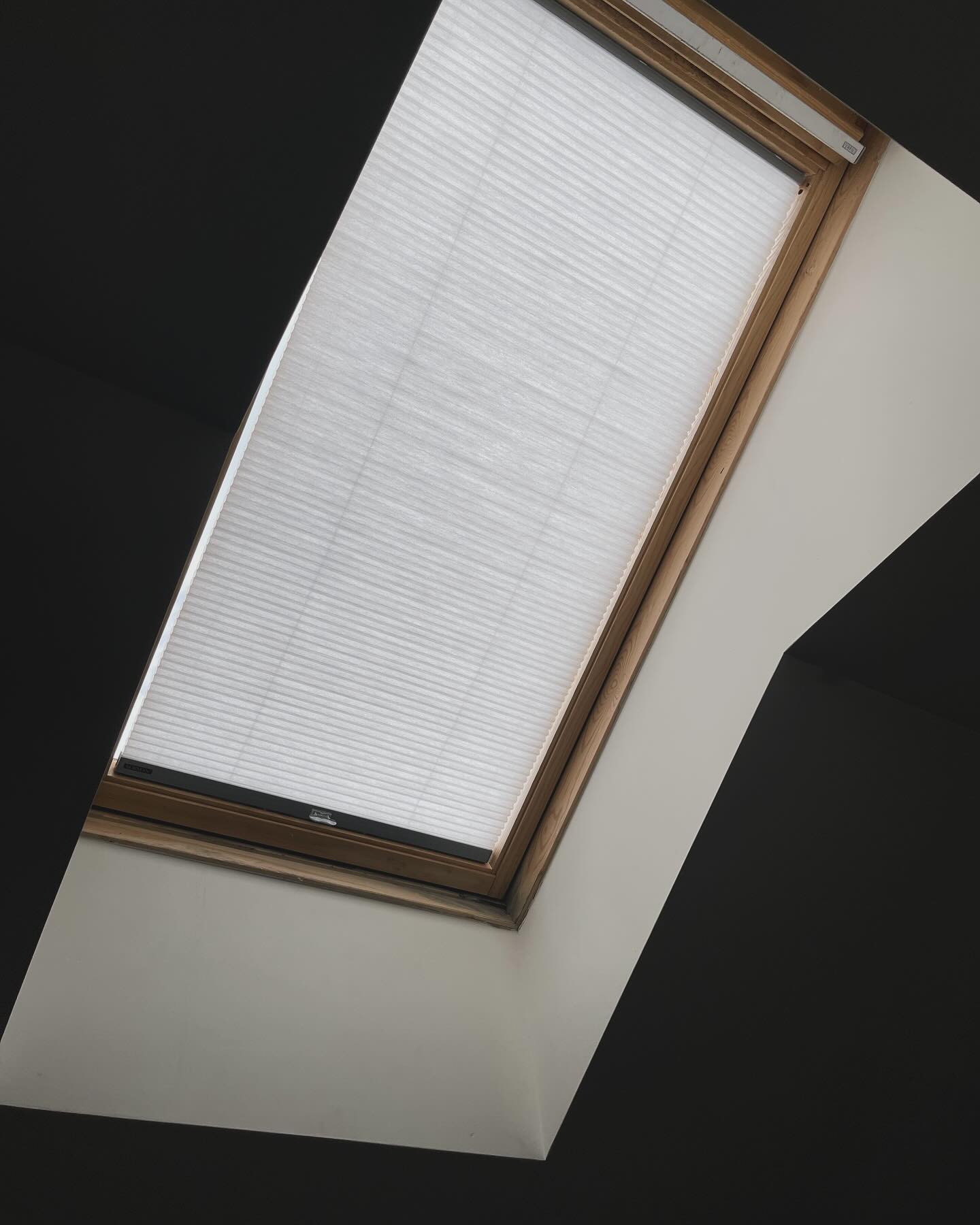 Skylight blinds honeycomb cellular shades installed on a ceiling window.