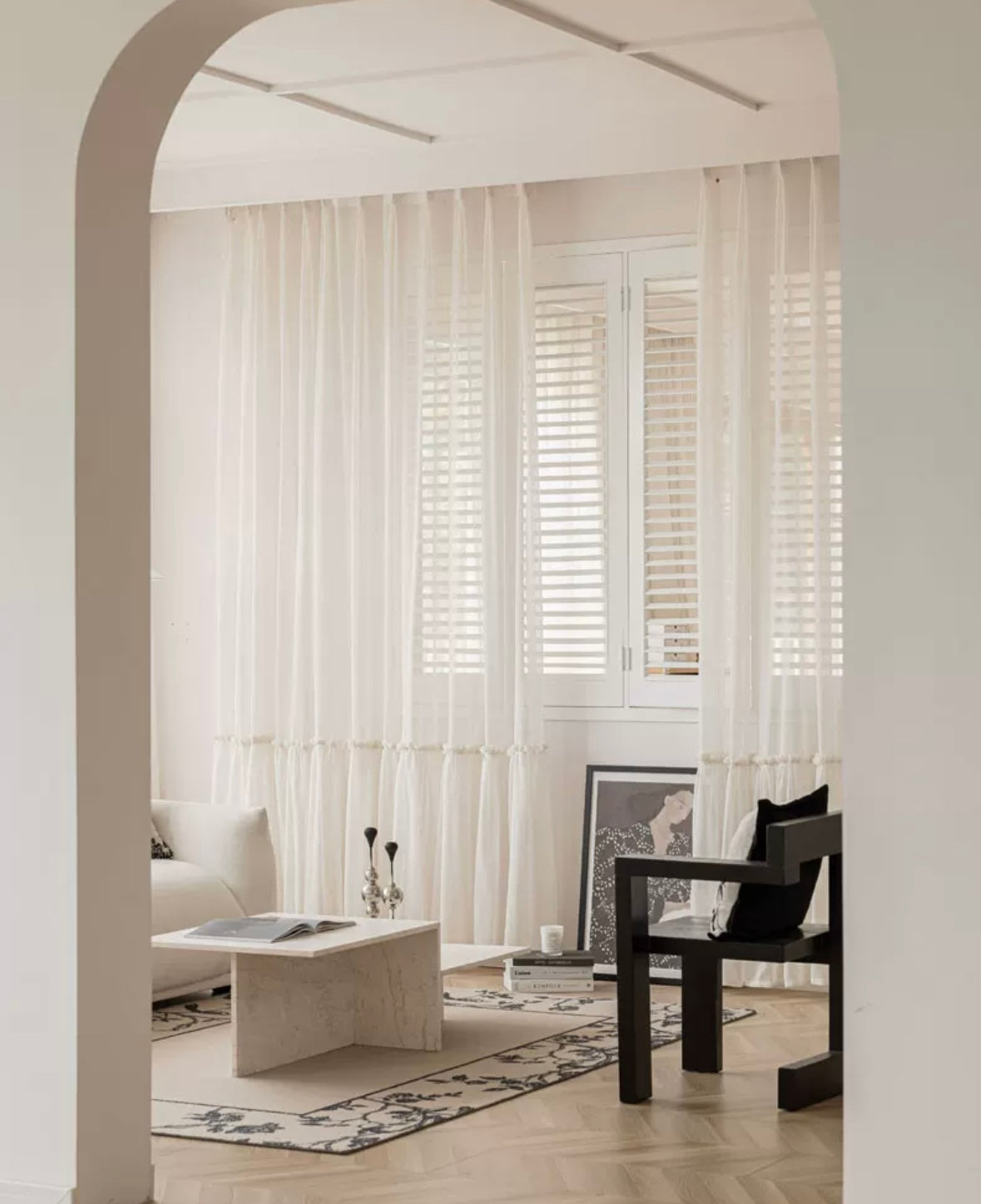 Cream sheer curtains with ruffled hem in a softly lit room.