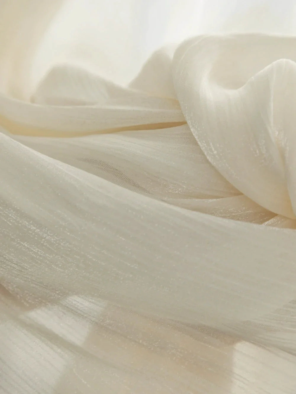 Cream-colored sheer curtains with radiant shimmering finish and soft translucent texture for sunrooms