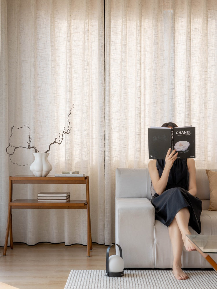 Black-trimmed sheer linen curtains in living room setting.