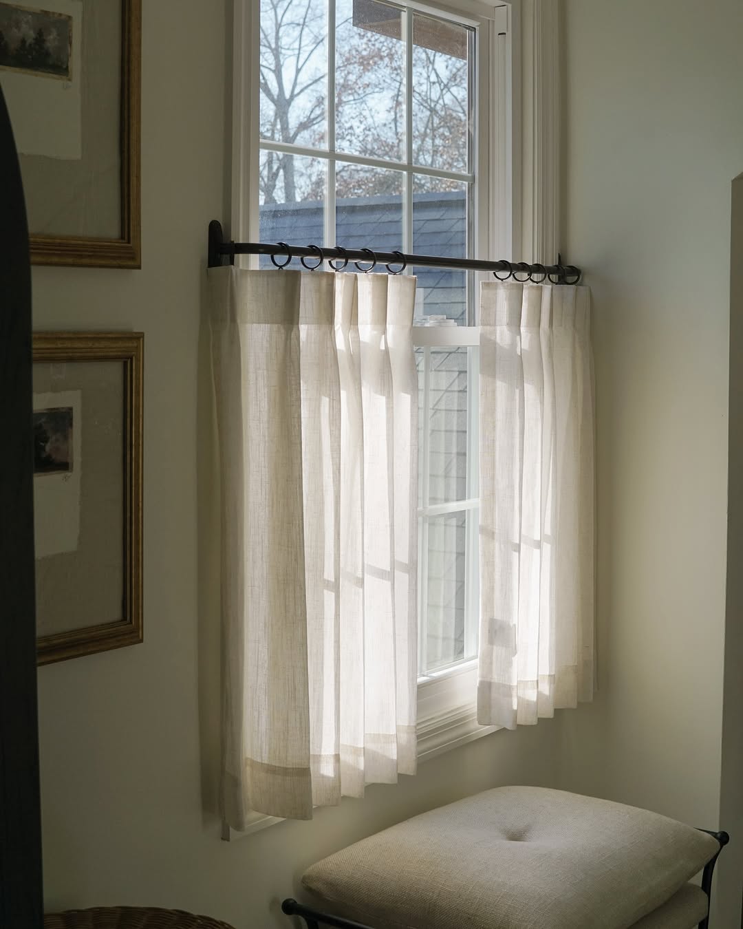 Custom cafe curtains in beige fabric on window, providing light control and a cozy atmosphere.