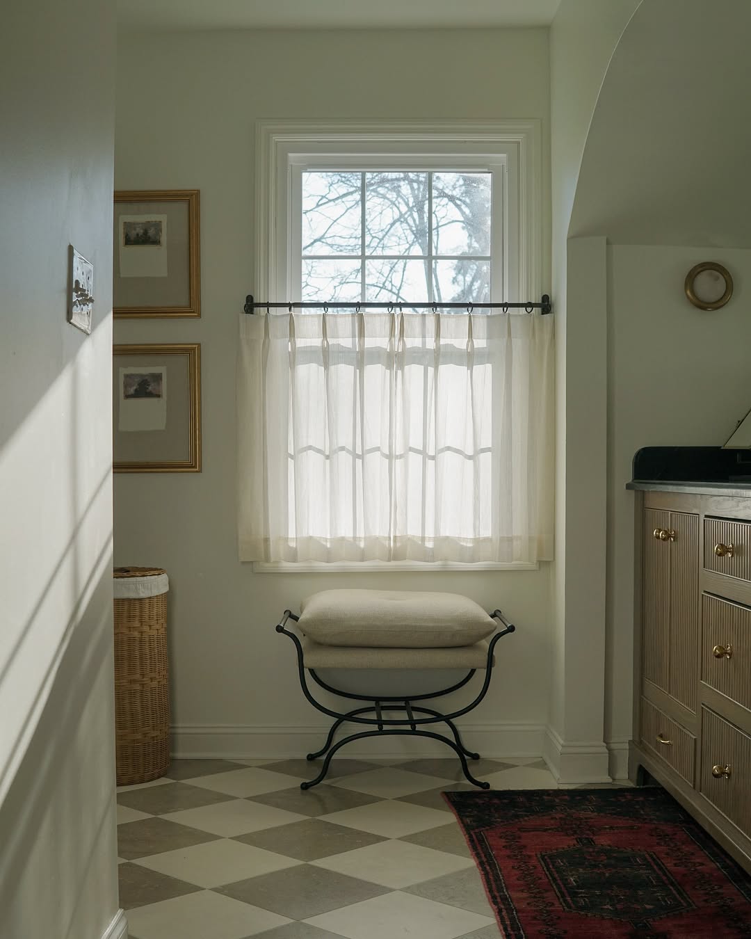 Custom cafe curtains in neutral color hung on a window, providing light control and privacy in a cozy room setting.