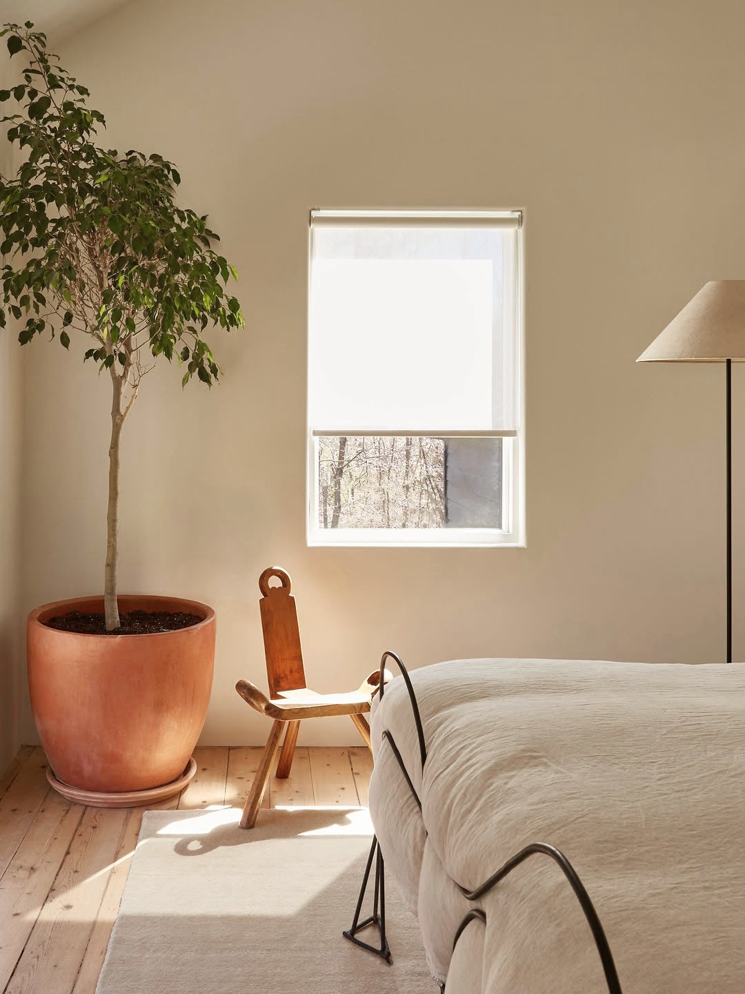Cordless natural woven linen roller shades in a modern bedroom.