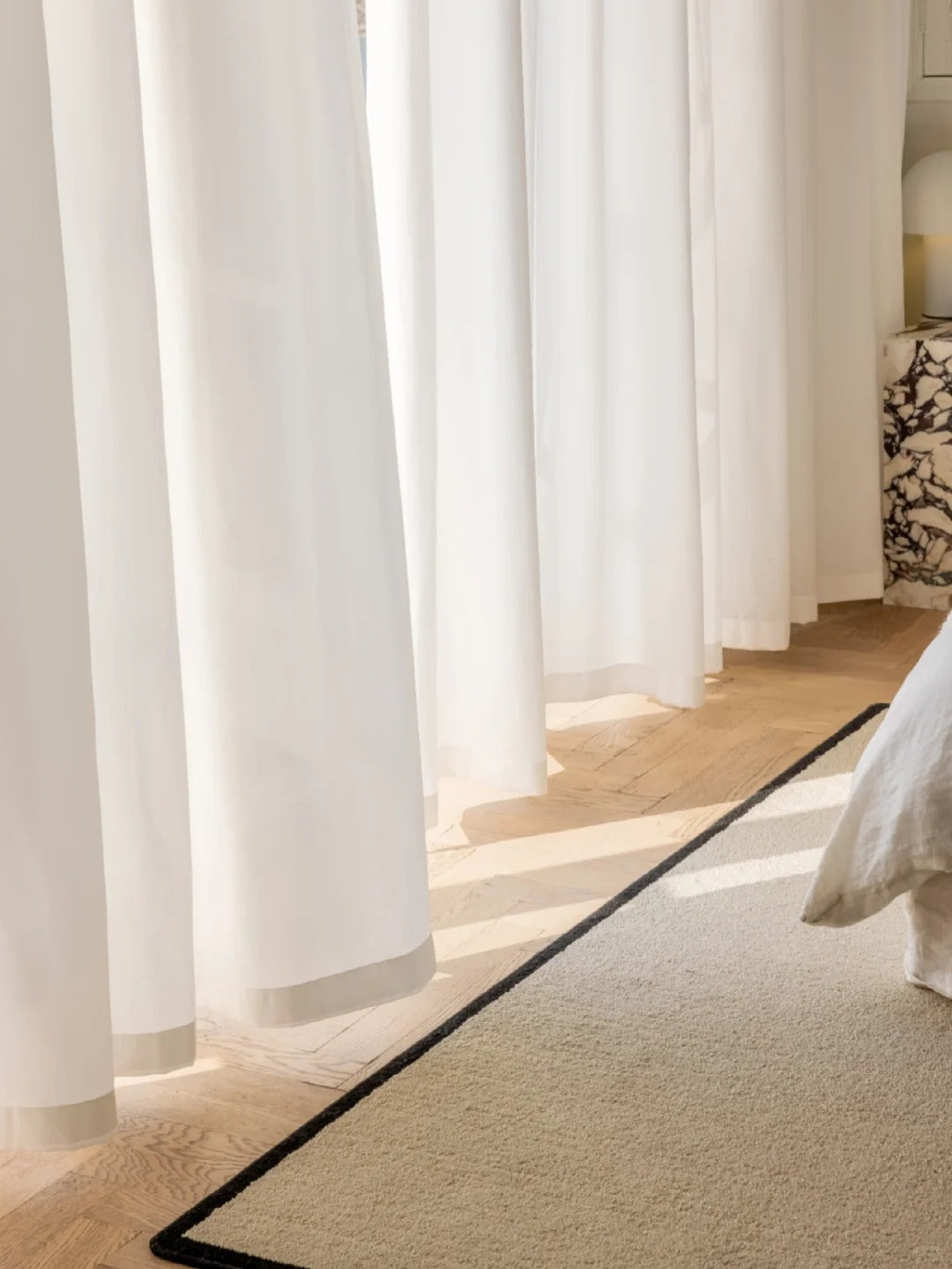 White sheer curtains on a sunlit window, enhancing privacy and light penetration.