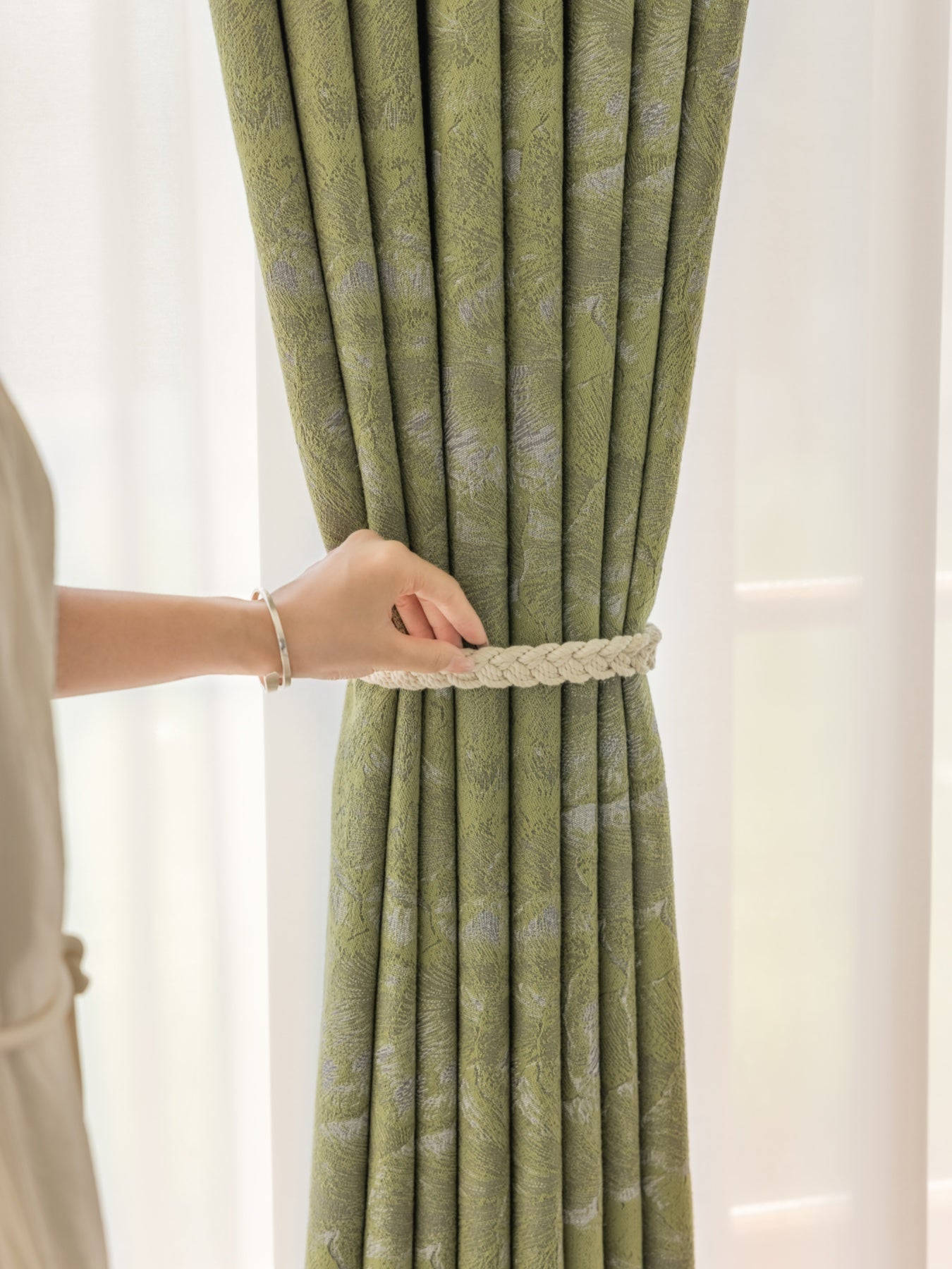 Green ginkgo leaf jacquard curtain with blackout fabric held by hand