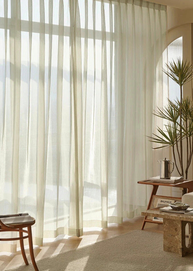 Cream sheer curtains in sunroom with soft natural light and modern decor