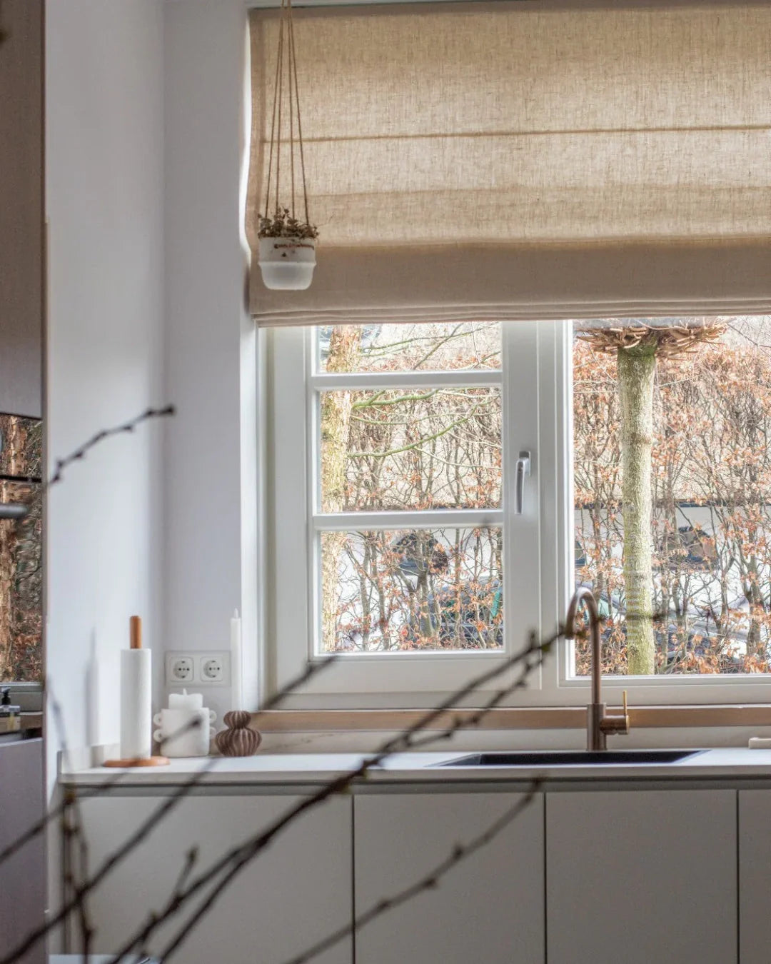 Cordless custom Roman shades in plain fold, light-filtering fabric in a modern kitchen.