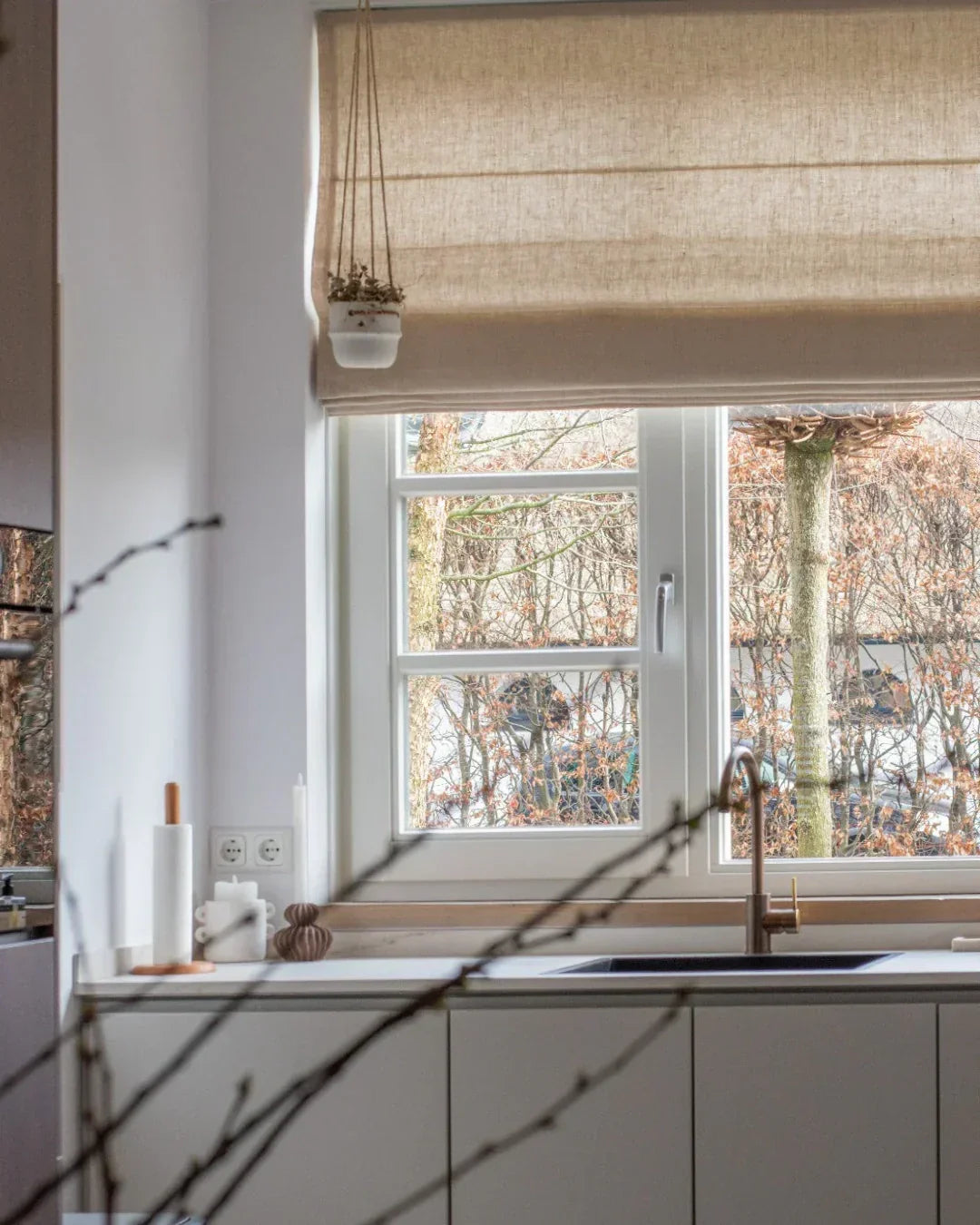 Cordless custom Roman shades in plain fold, light-filtering fabric in a modern kitchen.