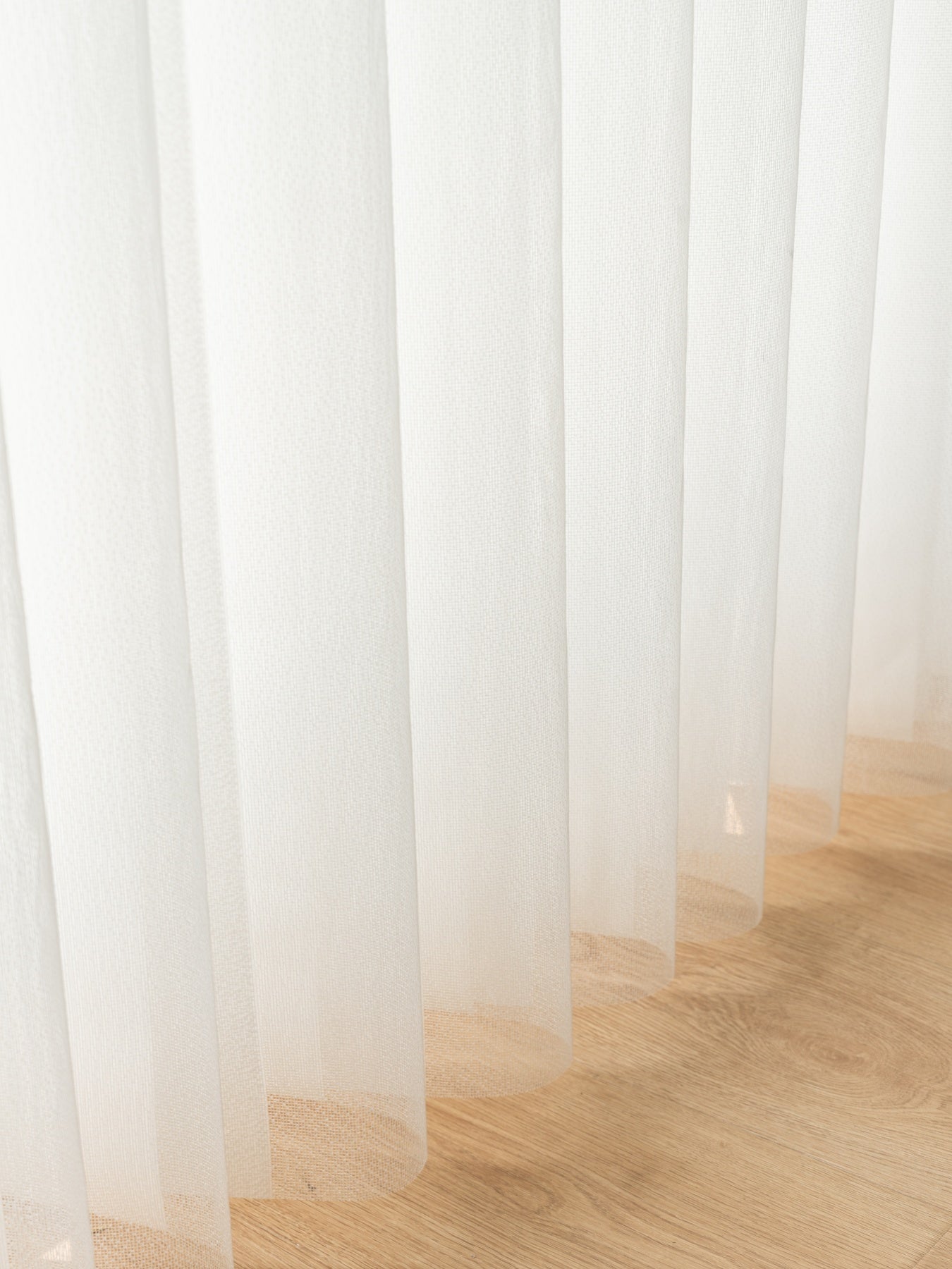 Vertical premium sheer curtain panels sliding horizontally with adjustable vanes on large sunny windows