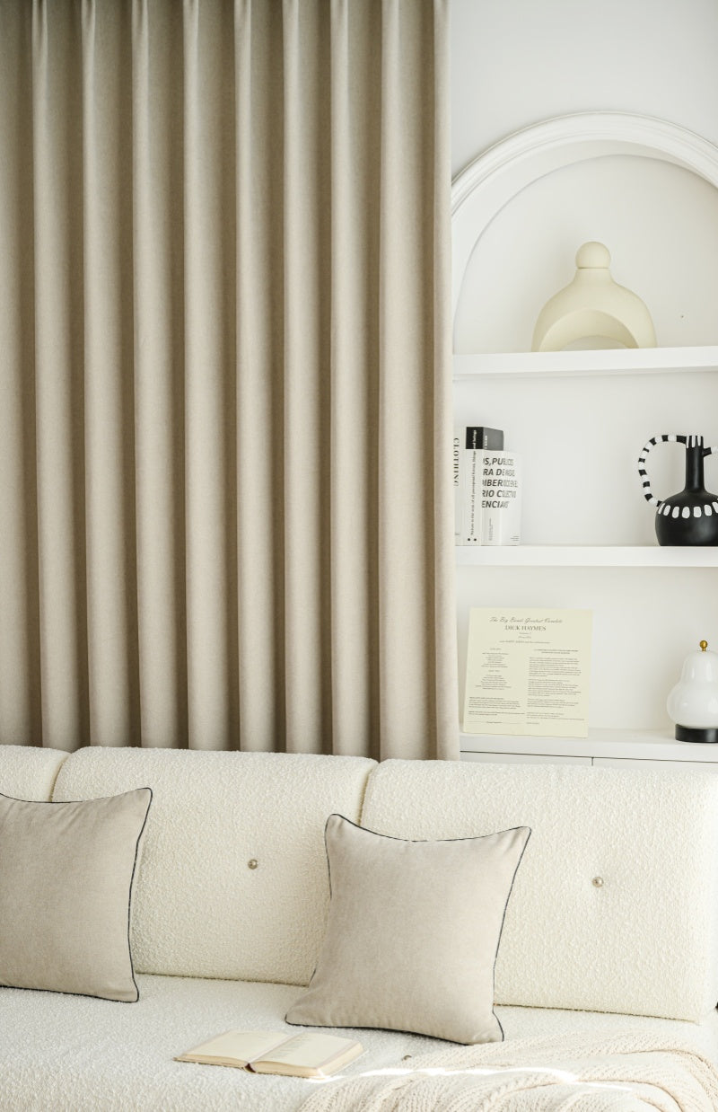 Luxury cashmere texture blackout curtains, pleated design, in cozy living room setting.