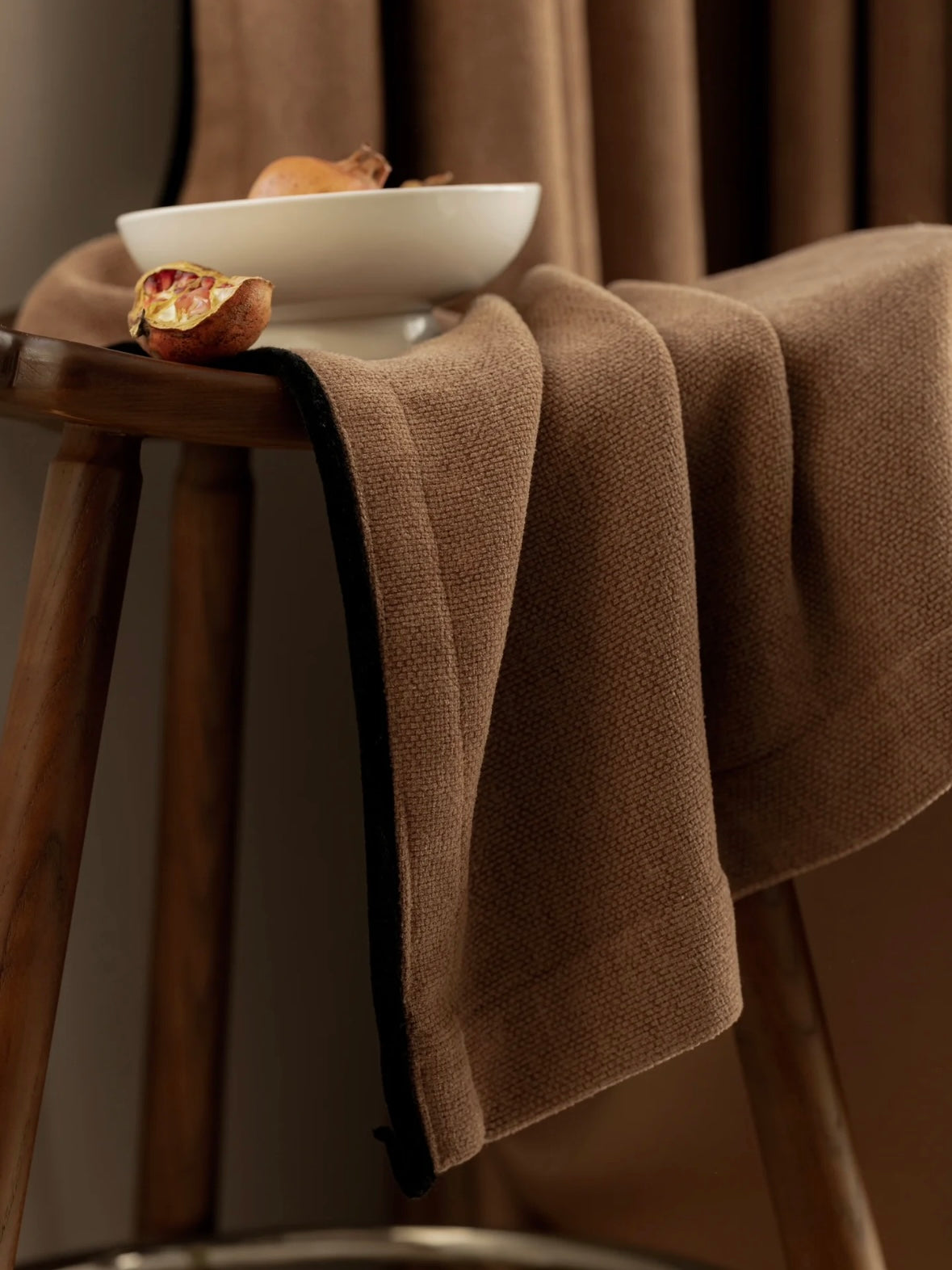 Heavyweight chenille blackout custom curtains in brown, draped over chair.