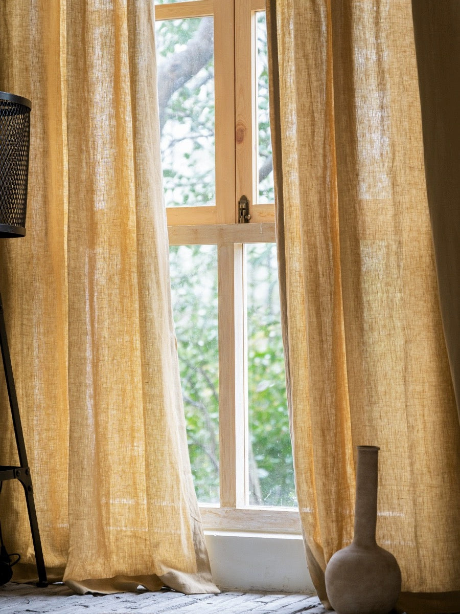 Mustard yellow curtains made of 100% French linen with a soft, muted hue and breathable fabric.