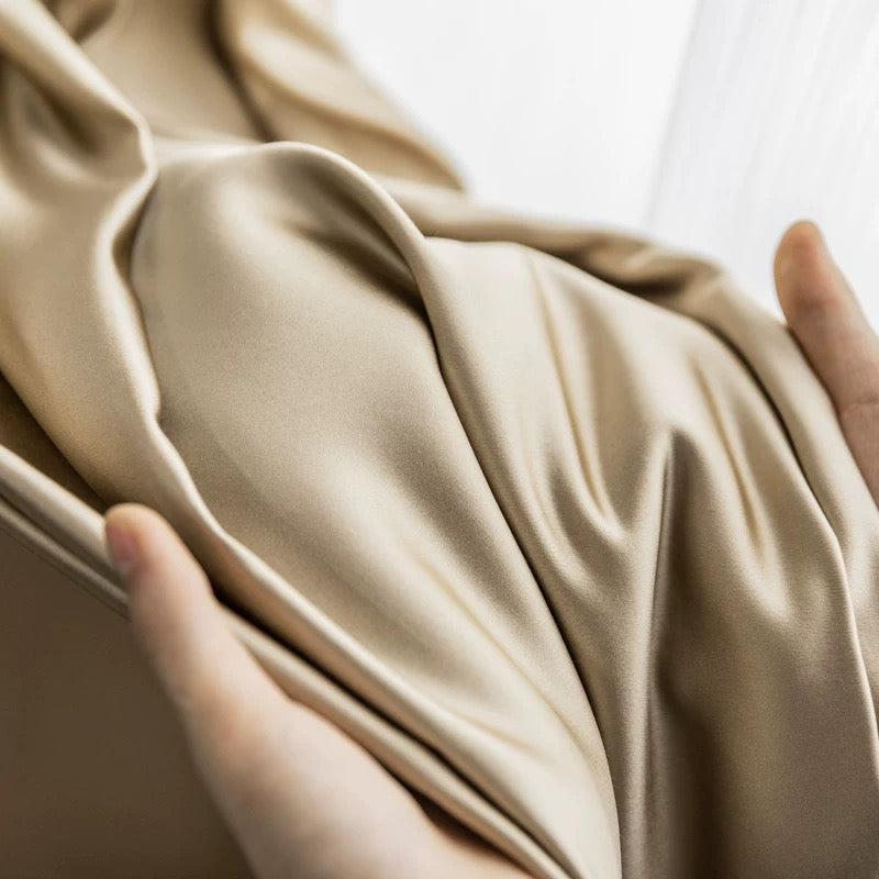Close-up of smooth, luxurious silk curtains in a soft, elegant hue.