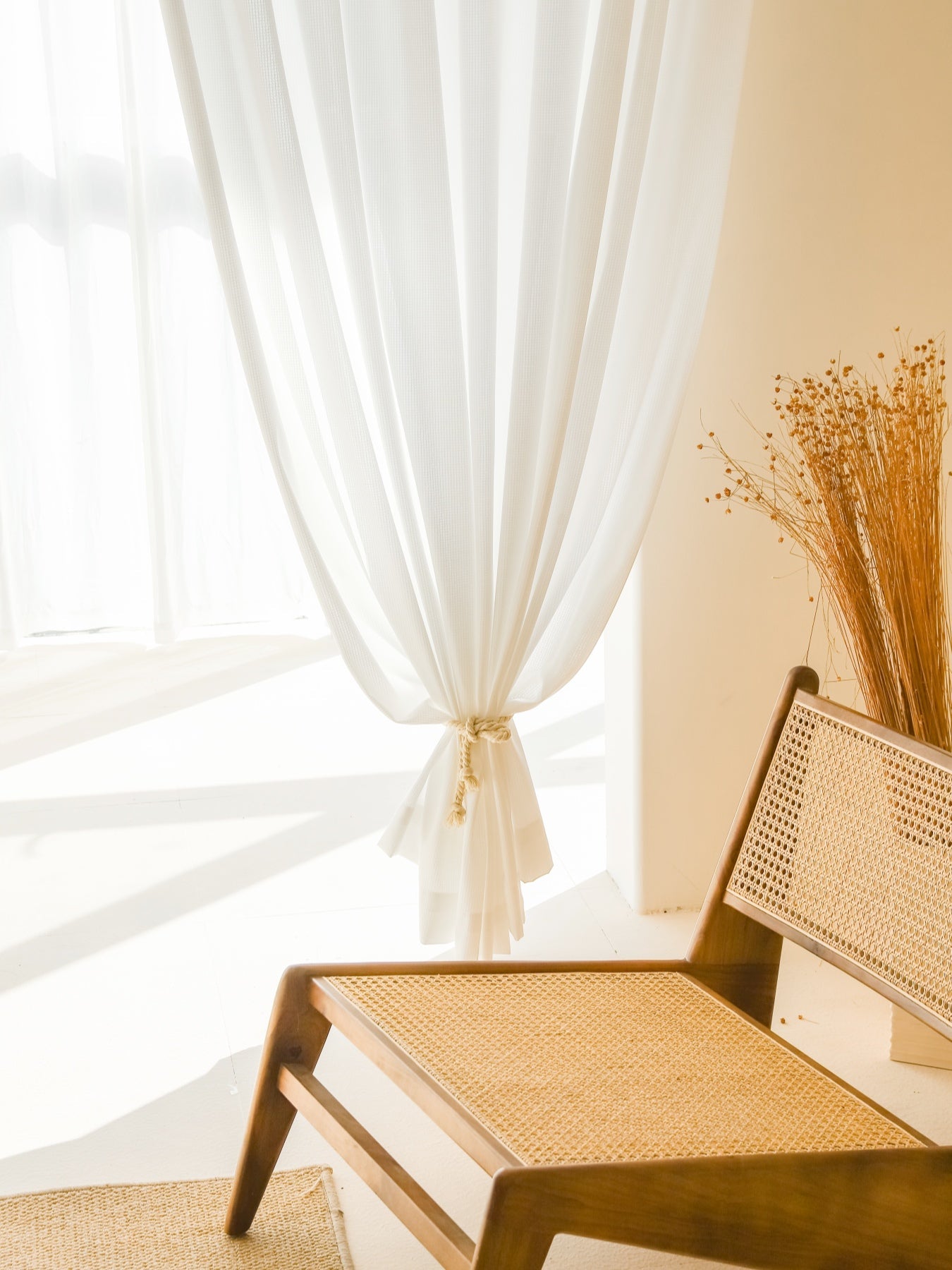 White sheer curtains with waffle pattern in a sunlit living room, providing premium sun-blocking and thermal insulation.