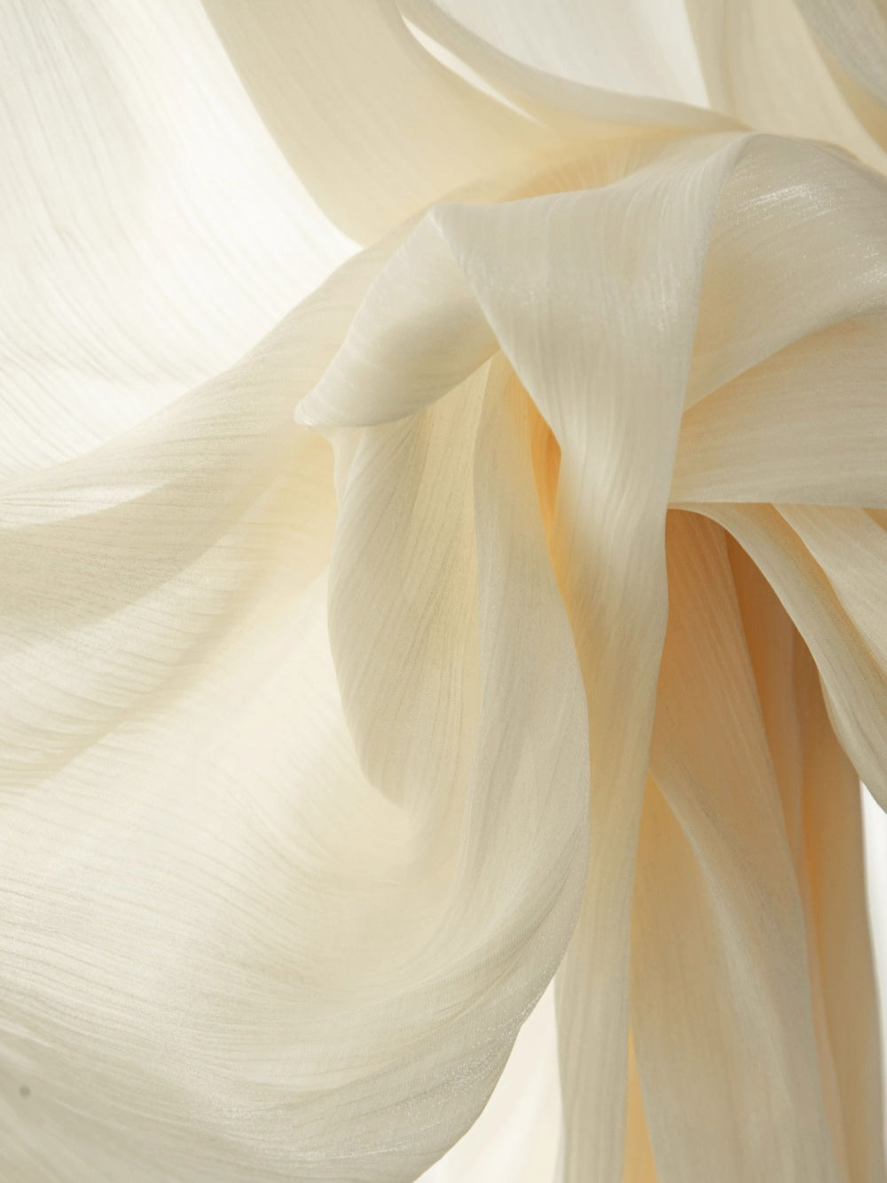 Cream sheer curtains with shimmering pearlescent finish, offering elegance and privacy.
