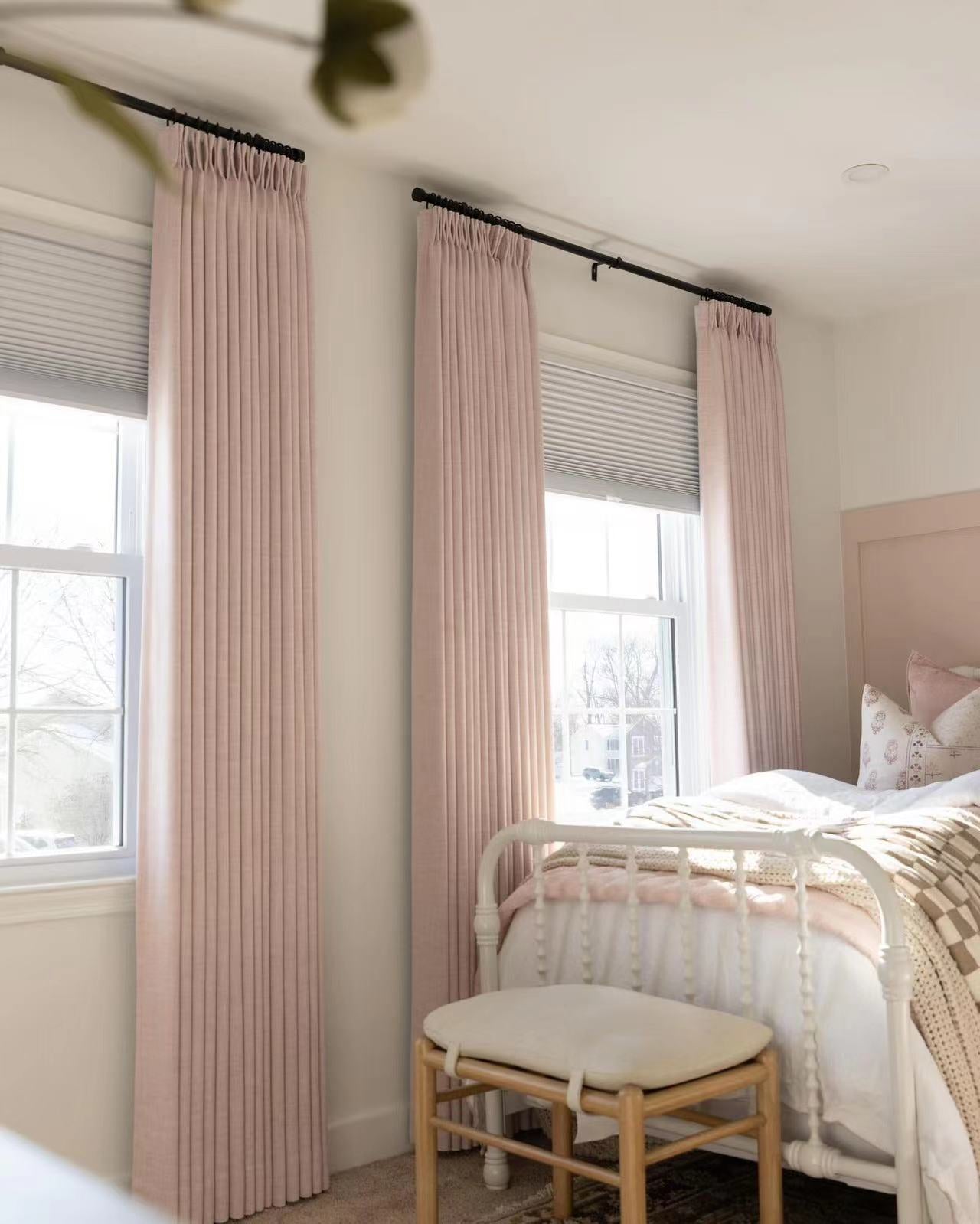 Linen blackout curtains with pinch pleat drapes in a cozy bedroom setting, providing privacy and style.