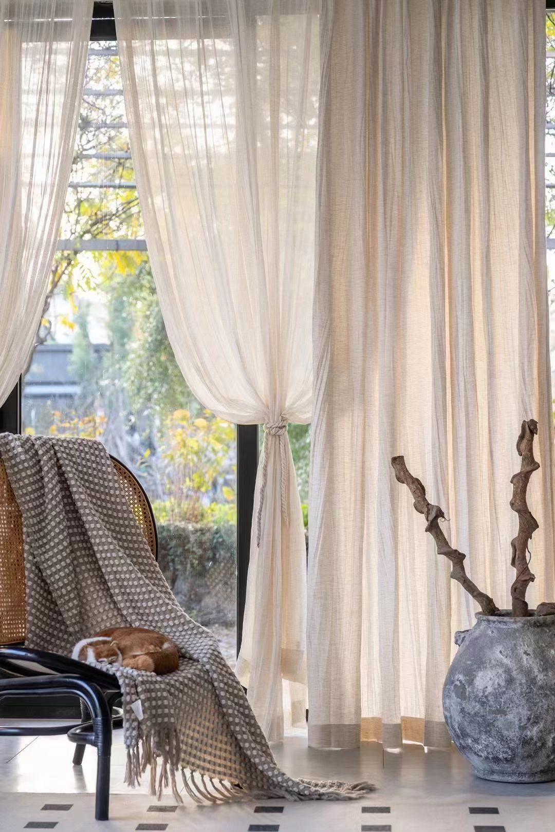 Lightweight crinkled linen gauze drapes filtering light in a cozy living room setting.