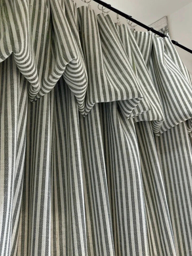 Classic linen striped curtains in neutral tones with fine and bold vertical stripes hanging on a black curtain rod