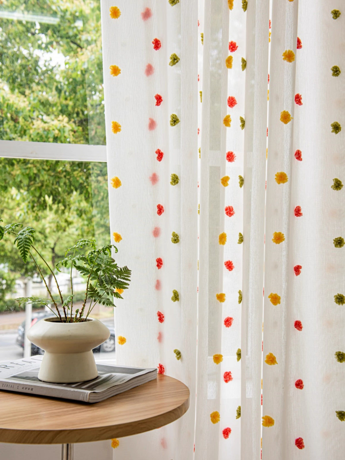 Colorful candy sheer curtains with rainbow pom-poms, perfect for kids' rooms.