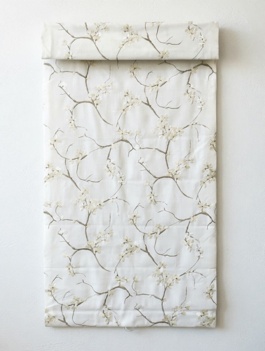 Patterned Roman Shades in ivory linen with delicate embroidered branches and blossoms, flat-fold design