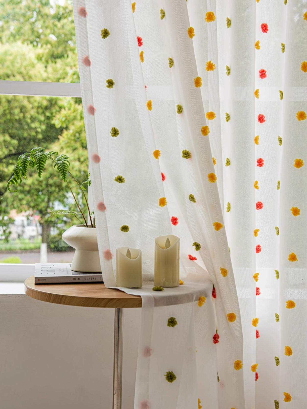 Colorful sheer curtains with rainbow pom-poms, ideal for kids' rooms, adding playful charm and warmth.