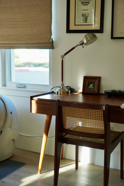 bamboo roman shades filtering natural light in home office with wooden desk and chair