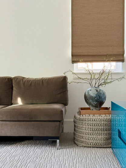 Brown bamboo roman shade in modern living room with sofa and decorative vase