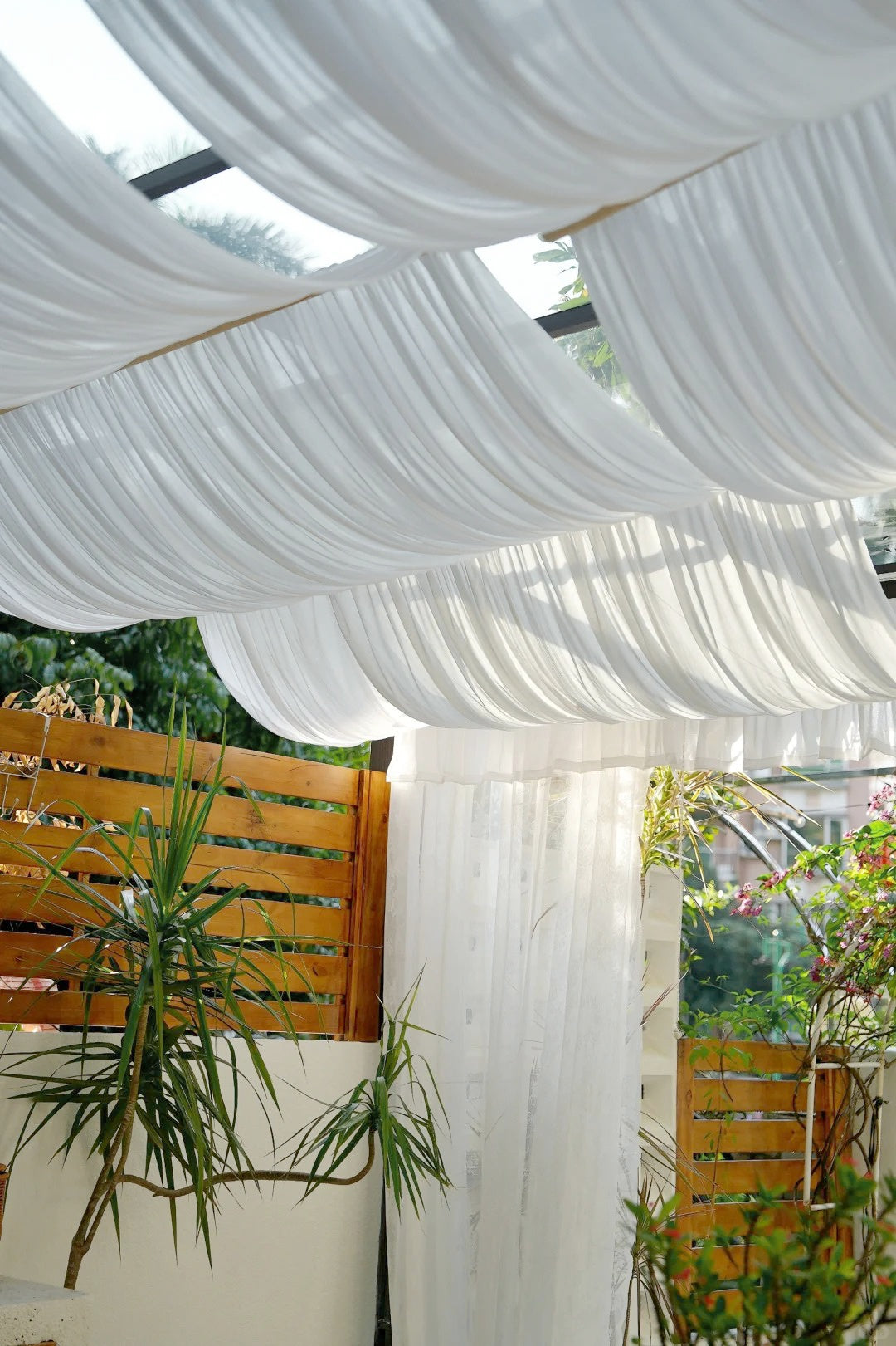 Outdoor curtains in a gazebo, showcasing sheer, UV-resistant, water-repellent fabric for patios and balconies.