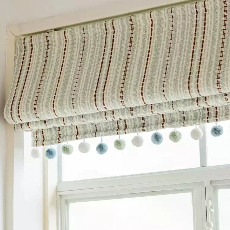 Striped curtains in Fair Isle Jacquard blackout design with playful pom-poms, perfect for a child's playroom.