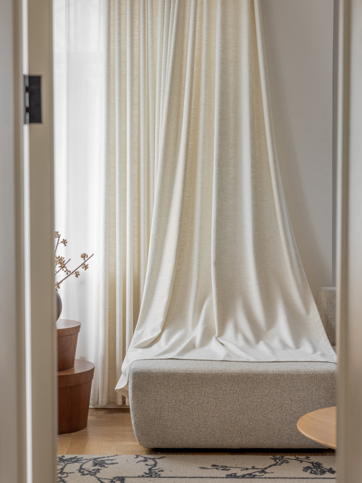 Luxury white linen curtains draped in a modern living room setting.