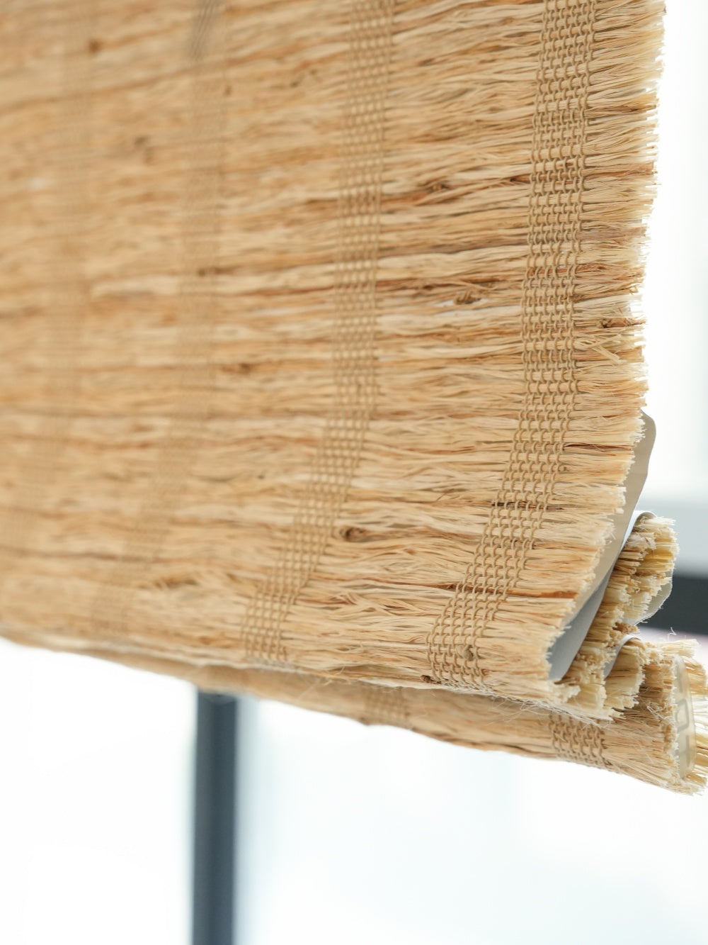 Honey-colored natural ramie woven shades with breathable weave and textured finish for modern and rustic home decor