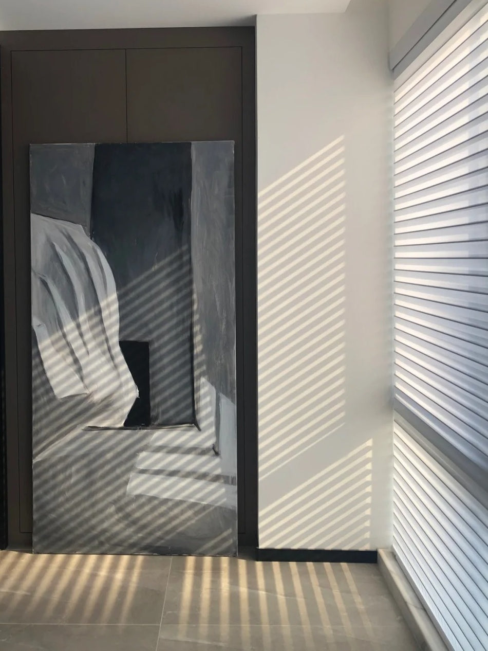 Contemporary interior with Shangri-La Sheer Shades filtering sunlight beside abstract wall art, enhancing privacy and light control in a stylish setting