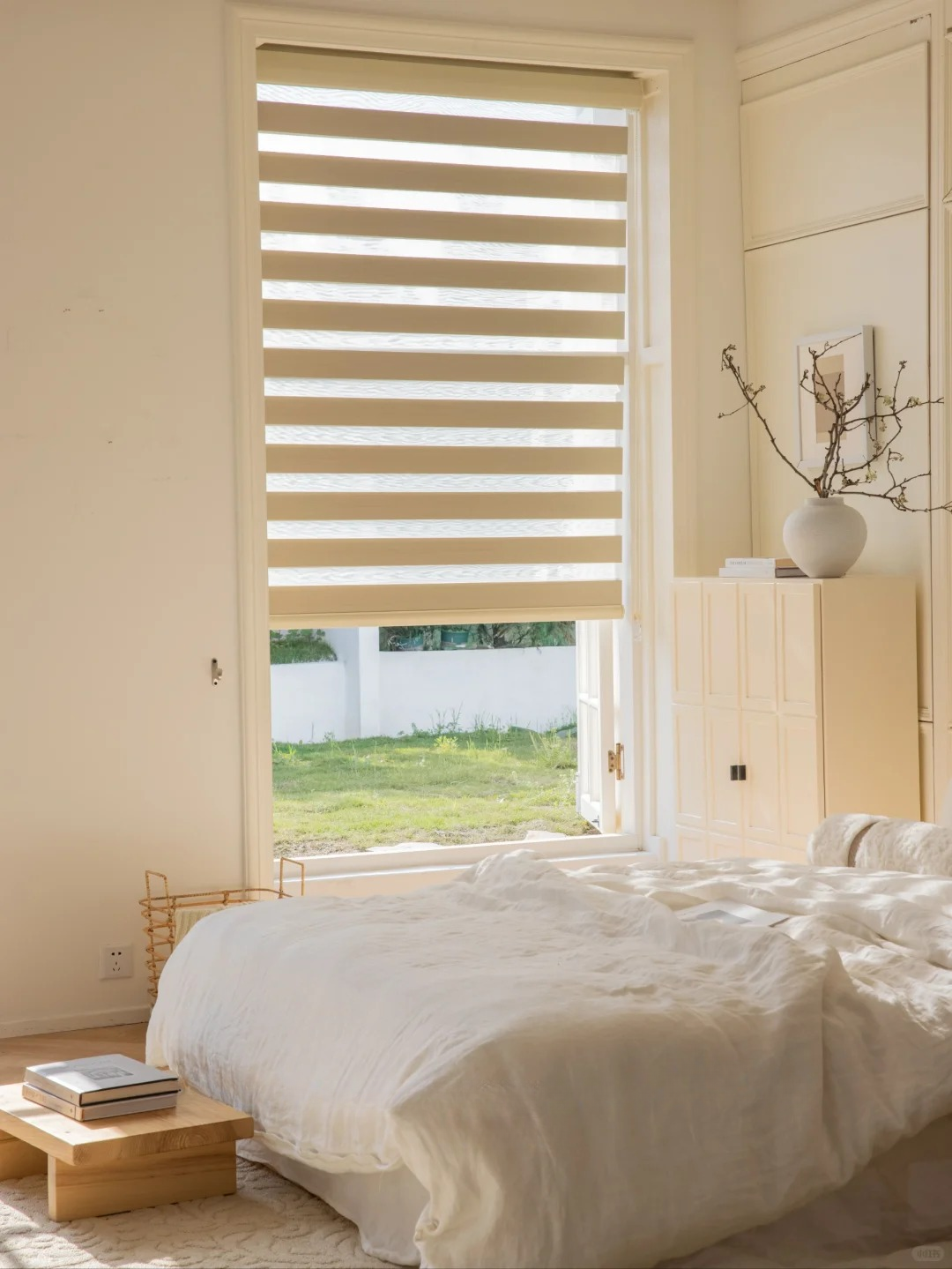 Zebra blinds with alternating sheer and solid fabric in a bright bedroom window providing adjustable light control and privacy.