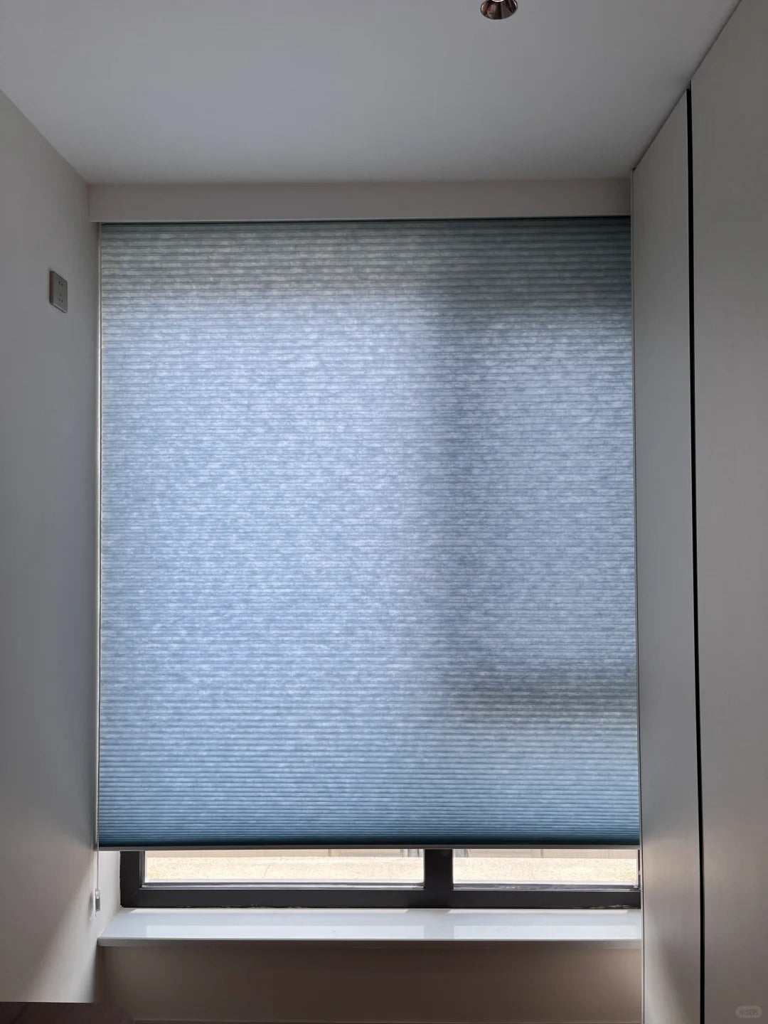 Deep blue dual-cell honeycomb shades with large apertures, exuding elegance and sophistication, perfect for a gentleman's space.