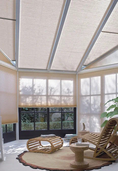 Sky Canopy Honeycomb Drapes in sunroom featuring beehive pattern for light diffusion, with stylish interior furnishings including a wooden lounge chair