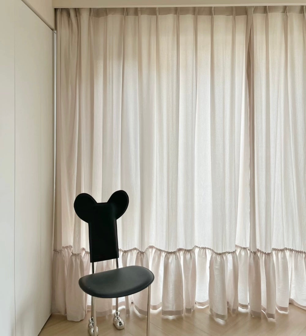 Elegant sheer curtains with ruffled hem in a princess room, complemented by a unique black mouse ear chair, enhancing a soft and luxurious ambiance