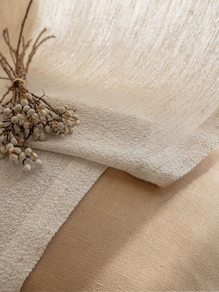 Close-up of oatmeal-hued linen-wool blend sheer curtain with decorative dried berries enhancing the natural texture