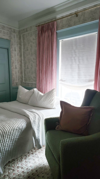 Relaxed Roman shades on window with soft curved bottom, light filtering linen fabric in modern bedroom setting