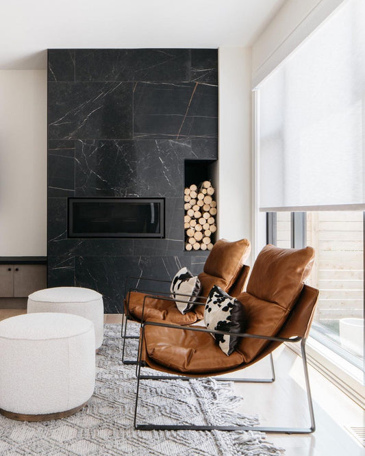 A sleek living room with a black marble fireplace, exuding modern elegance. UV Blocker Roller Blinds add a touch of sophistication.