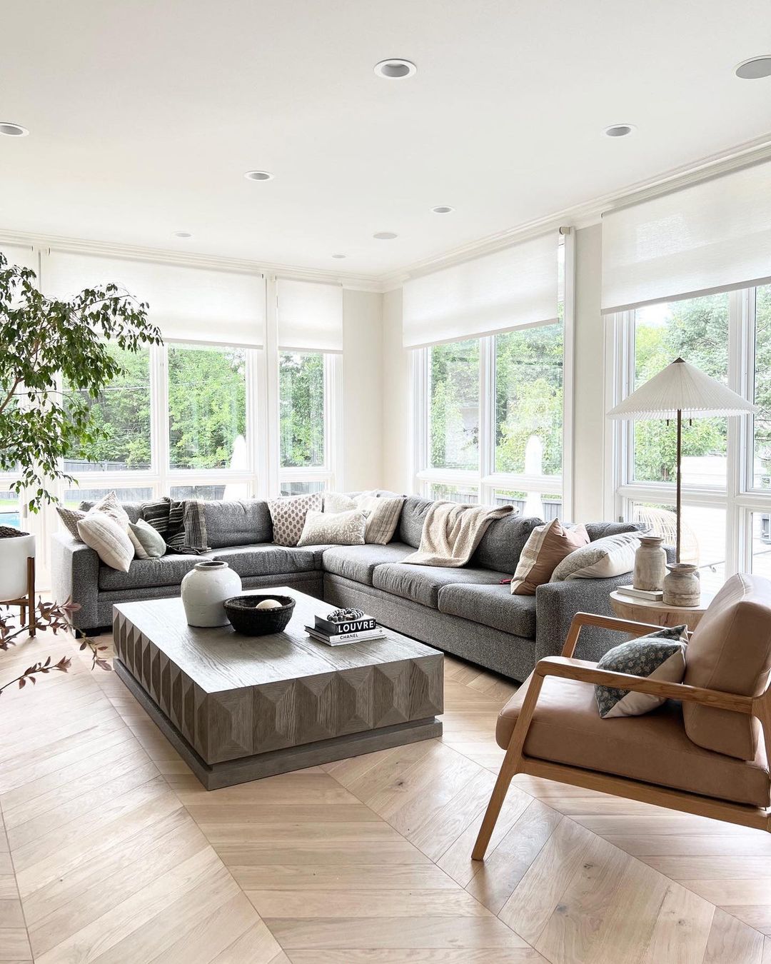 A sleek living room with a black marble fireplace, exuding modern elegance. UV Blocker Roller Blinds add a touch of sophistication.