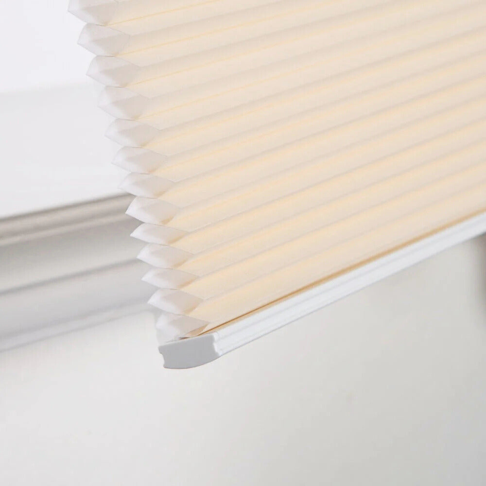 close-up of beige no-drill honeycomb shades with cordless, easy-install design on window frame