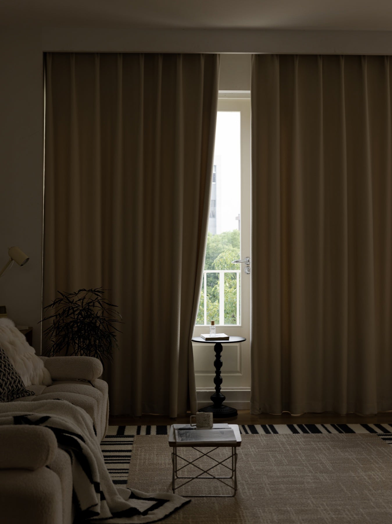 Elegant heavyweight linen blend drapery in beige framing a window with a view in a modernly decorated room, perfect for minimalist interior designs