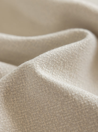 Close-up of heavyweight linen blend drapery in light beige, showing textured weave for durable and eco-friendly window treatments