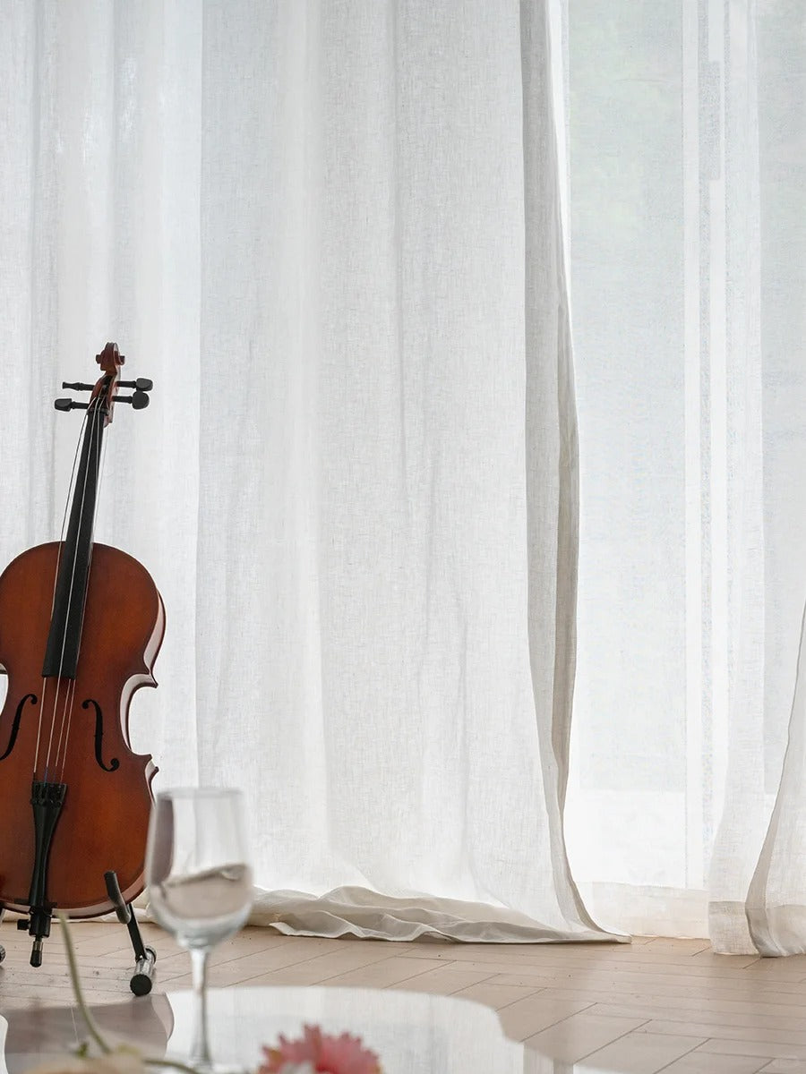 Elegant white linen curtains in a refined indoor setting with a cello and subtle floral decor, embodying sophistication and tranquility perfect for living rooms or studies
