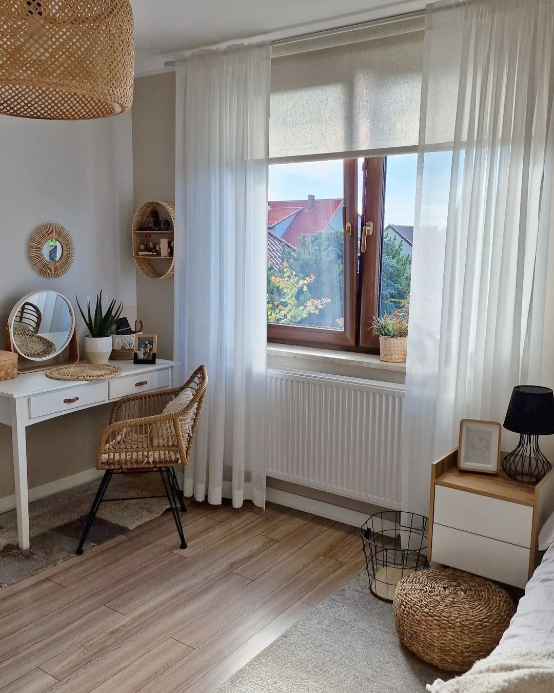 Linen roller shades in a cozy, light-filled room with wooden accents and a view outside.