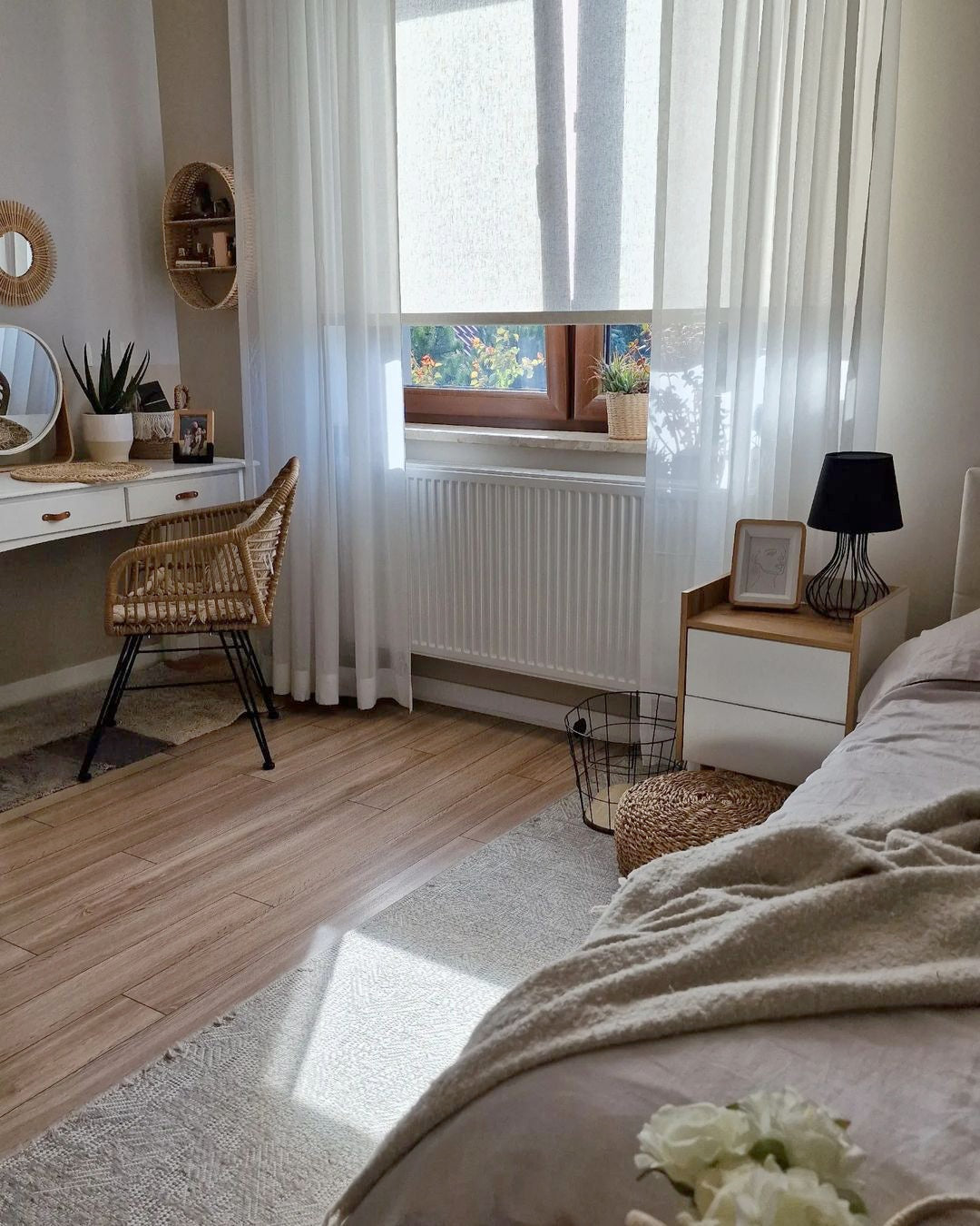 Cordless natural woven linen roller shades in a cozy bedroom.