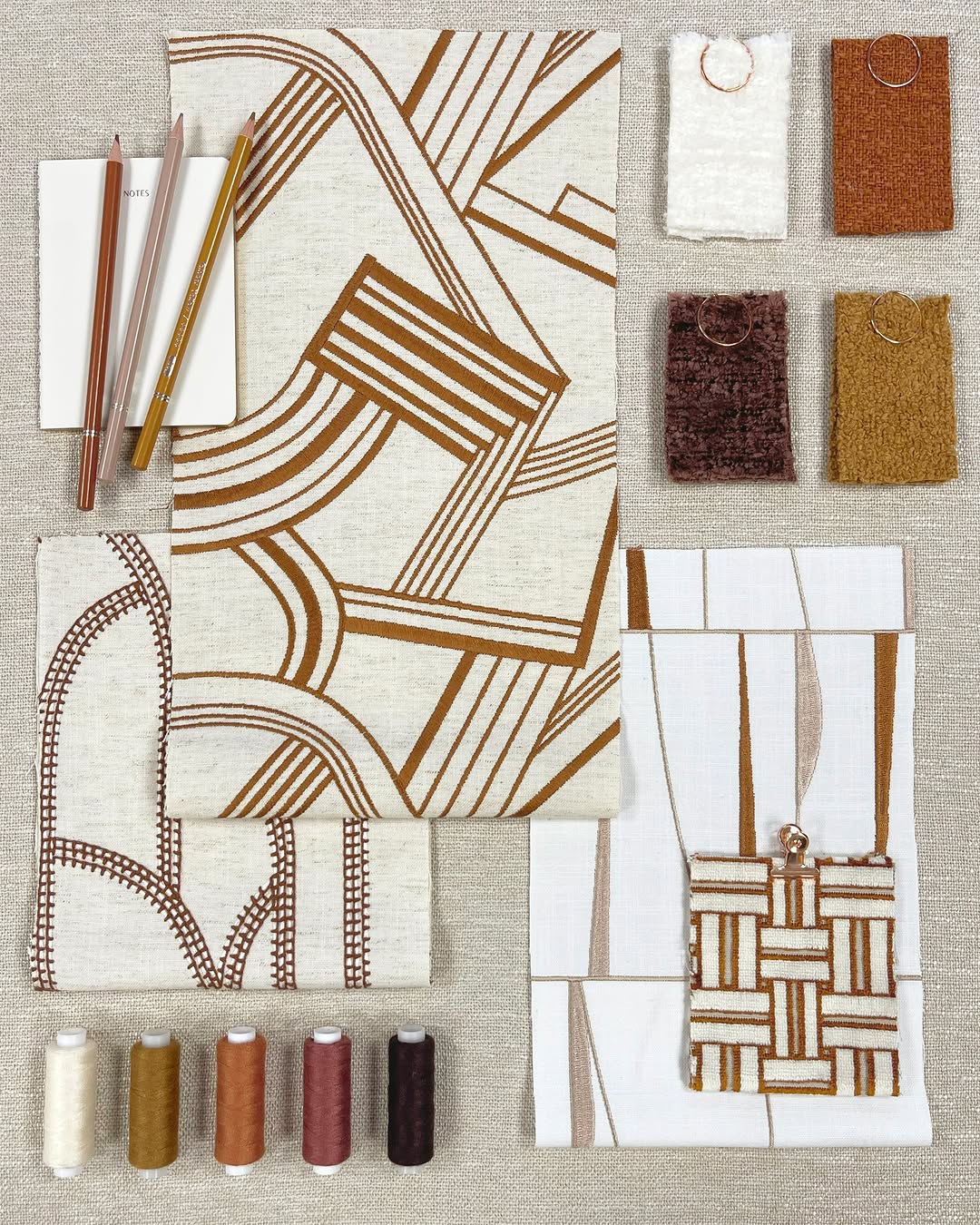 Patterned fabric Roman shades in flat fold style, showcasing modern textures and timeless prints, with sample fabrics and accessories.